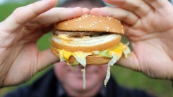 In this photo-illustration a man holds a burger from a fast food outlet on January 7, 2013.