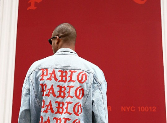 A fan wearing a jacket designed by Kanye West poses outside 83 Wooster Street in Soho at the Kanye West 'Pablo Pop-Up Shop' In Manhattan on March 18, 2016 in New York City.