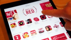 n this photo illustration a visitor tries out (RED) apps on an iPad at the Apple Store on December 1, 2014 in Berlin, Germany. 