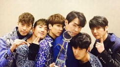 Shinhwa pose after winning the Show Champion award for their song 