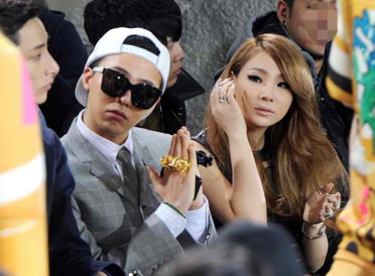 G-Dragon (L), a member of the popular South Korean boyband Big Bang, and CL (R), a member of the K-pop girlband 2ne1, watch a fashion show held in Seoul on March 28, 2013. 