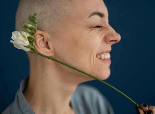 woman smiling holding white flower