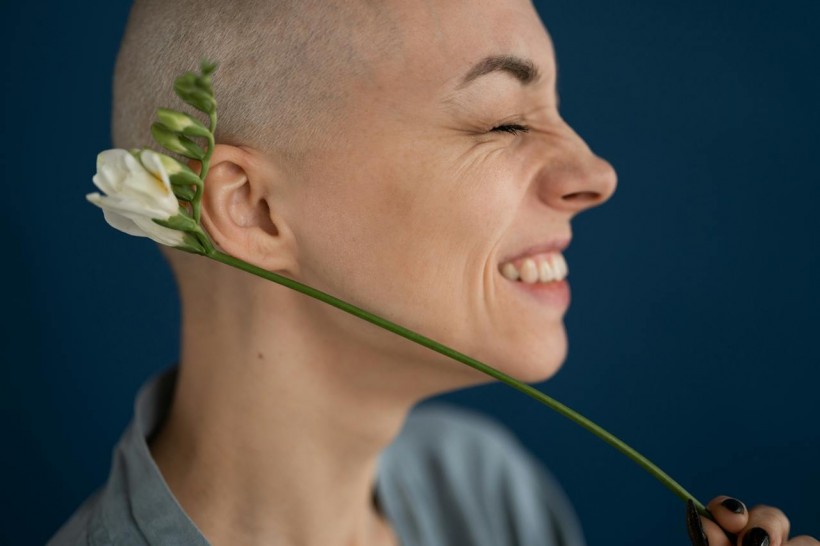 woman smiling holding white flower