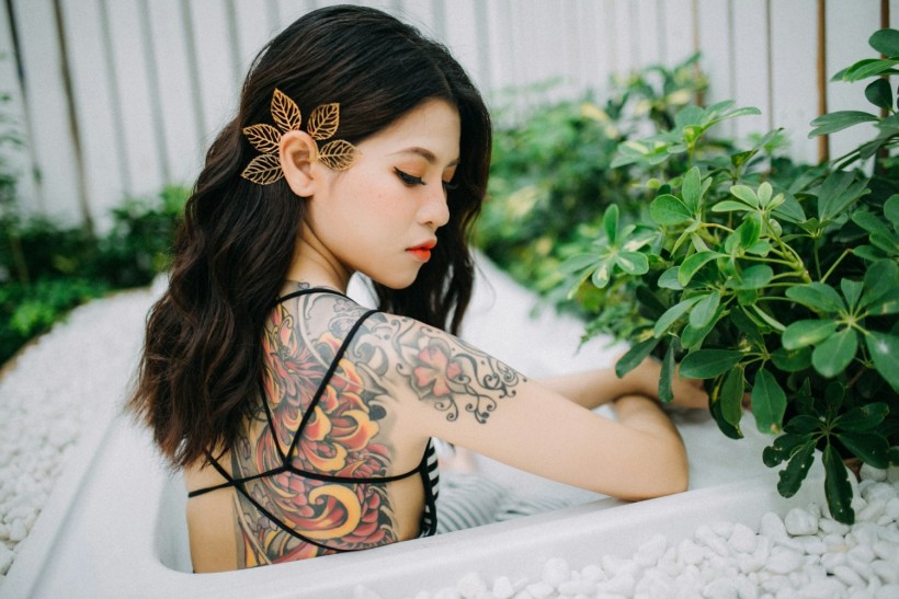 asian woman with back tattoo