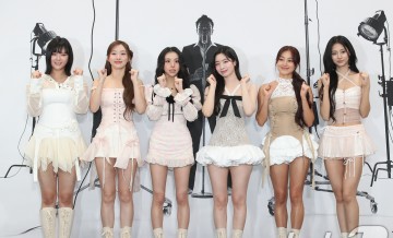 The members of TWICE are posing at the 'Ddanddara JYP' photo wall event